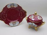 two pieces of red and white porcelain with gold trimming