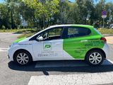 the green and white car is parked on the side of the road