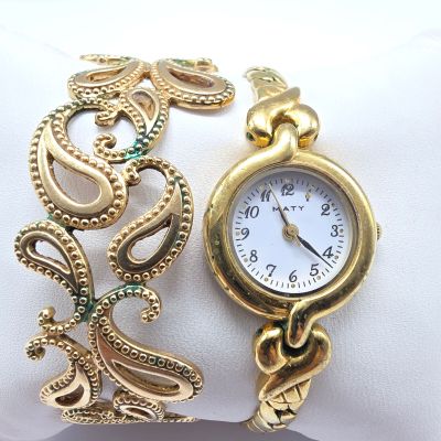 une montre-bracelet en or à laquelle est attachée une chaîne