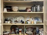 un placard rempli de vaisselle et de plats dans la cuisine