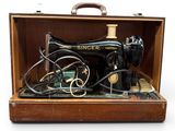 une vieille machine à coudre rangée dans un coffret en bois