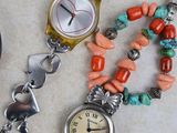 a close up of a watch and a bracelet on a table