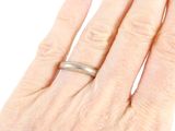 a woman ' s hand with a wedding ring on it