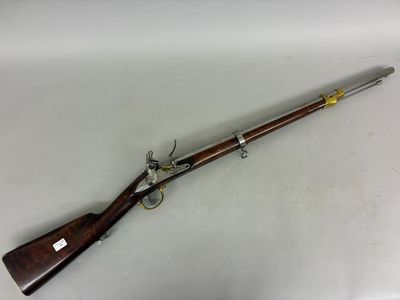 a rifle with a wooden barrel and brass fittings on a white surface