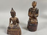 deux statues représentant un homme et une femme assis sur des blocs de bois