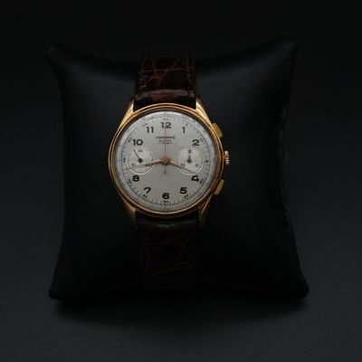 un gros plan d'une montre posée sur un oreiller, sur fond noir