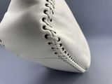 gros plan sur une balle de baseball en cuir blanc posée sur une surface bleue