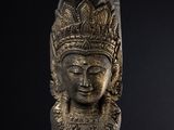 a close up of a statue of a head on a stand