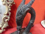 a statue of a bird on a table with a mirror in the background