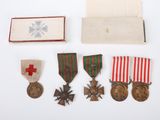 an assortment of medals including a cross, a medal, and a medal box