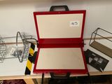une valise rouge posée sur une table, avec une étiquette de prix dessus