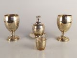 trois vases en argent posés les uns à côté des autres sur une table