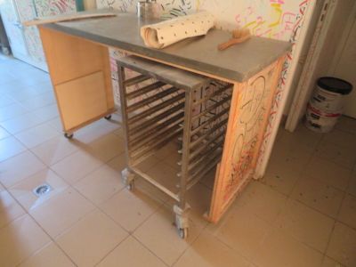 une table sur laquelle sont posés plusieurs plateaux, dans une pièce