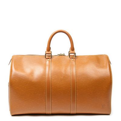 a brown leather duffel bag sitting on top of a white surface
