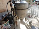 un grand pot en ciment posé par terre à côté d'un tas de bois