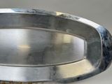 a metal tray with a metal handle on a table