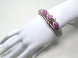 bracelet posé sur la main d'un mannequin, orné de pierres roses