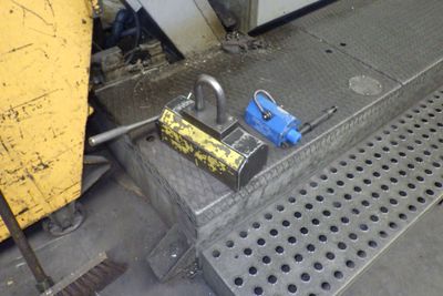 un cadenas posé par terre à côté d'une boîte jaune