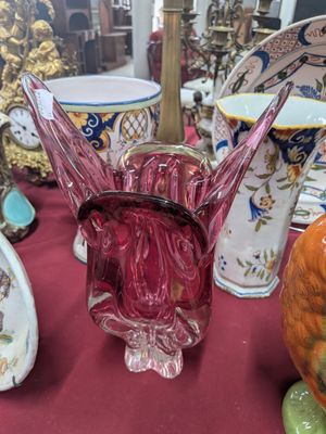 de nombreux vases de toutes sortes posés sur une table recouverte d'une nappe rouge