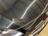 a close up of a car ' s headlight with a sticker on it