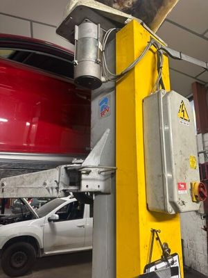 une photo d'un homme en train de travailler sur une voiture dans un garage