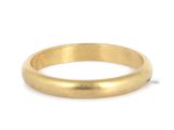 gros plan d'une bague en or sur fond blanc