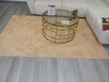 une table basse avec un plateau en verre posée sur un tapis dans un salon