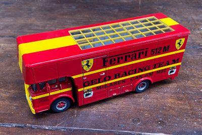 un bus à deux étages rouge et jaune posé sur un plancher en bois