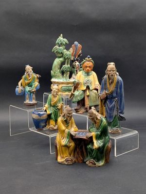 de nombreuses figurines représentant des personnes d'origine asiatique, posées sur une table