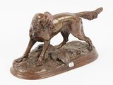 bronze statue of a dog on a rock on a white background