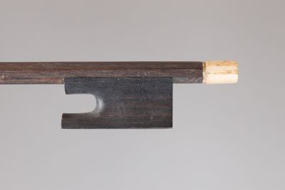 gros plan d'un archet de violon avec un morceau de bois qui en sort