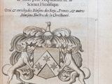 un vieux livre sur lequel figure le dessin d'un blason