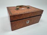 an old wooden box with a ring on top of it