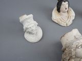 three statues of people with hats on them on a table