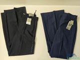 deux paires de pantalons pour homme, encore étiquetés, posées sur une table