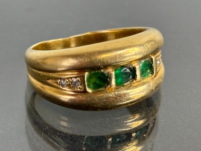 an image of a close up of a gold ring with emeralds