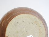 a brown and white vase with a tag on it