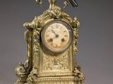 une horloge en or surmontée d'un oiseau
