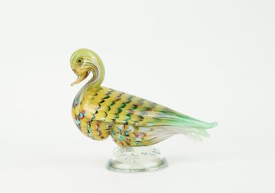 a glass bird that is sitting on top of a glass stand