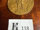 une pièce d'or posée sur une table, à côté d'un autocollant