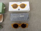 a pair of sunglasses, a box, and a pair of glasses on a table