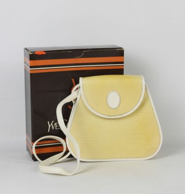 un sac à main orange et blanc posé à côté d'une boîte noire et blanche