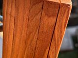 close up of a wooden post with a metal fence post in the foreground