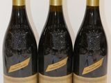 trois bouteilles de vin sont alignées sur une surface blanche