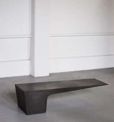 un gros plan sur un banc en bois dans une pièce aux murs blancs