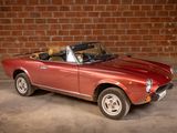 a red convertible car parked in front of a brick wall
