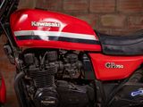 a red and black motorcycle parked in front of a brick wall