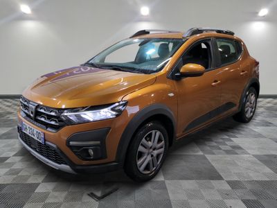 la voiture orange est garée sur le sol en damier d'un garage