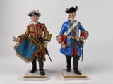 two figurines of two men dressed in military uniforms