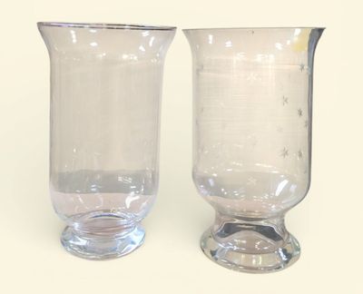 une paire de vases en verre transparent posés sur une surface blanche
